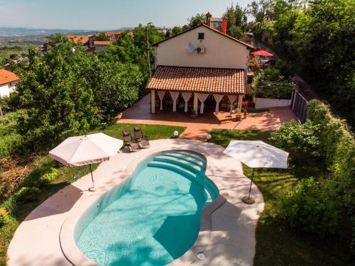 una vista aérea de una piscina con sombrillas y una casa en Apartment Nona Ančka en Marezige