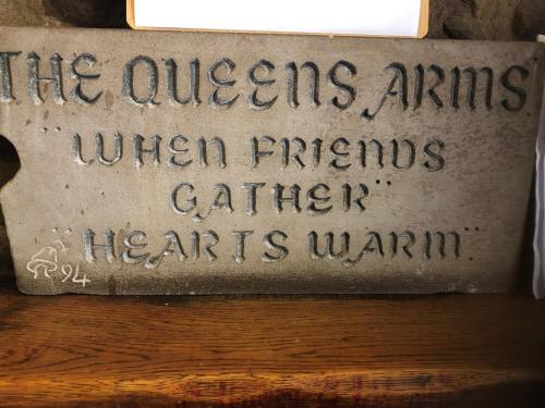 a stone sign that reads the queens arms when minerals catcher hearts warm at Queens Arms Litton in Litton