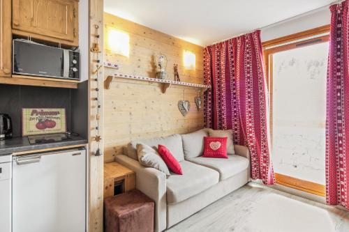 a living room with a couch in a tiny house at Residence Les Sentiers du Tueda - maeva Home in Méribel