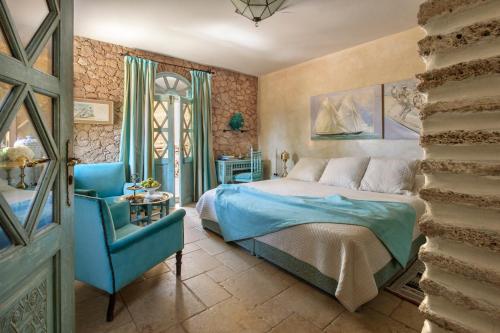 a bedroom with a bed and a blue chair at La Sultana Oualidia in Oualidia