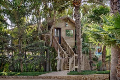 a house with palm trees in front of it at La Sultana Oualidia in Oualidia