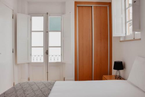 um quarto com uma cama e uma porta de madeira em Apartamento acolhedor e elegante em prédio típico - Self check in em Coimbra