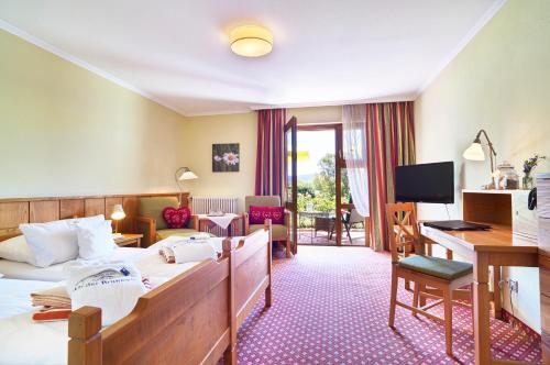a hotel room with a bed and a desk at Hotel An der Brunnader - Die Therme befindet sich 4 Geh-Minuten entfernt in Bad Birnbach