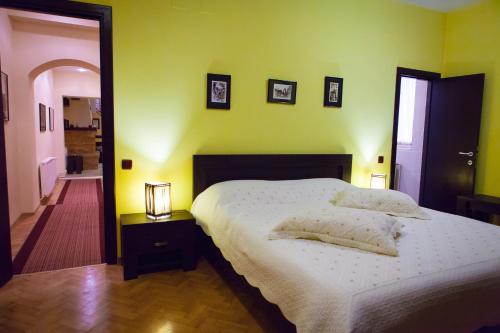 a bedroom with a white bed and a yellow wall at Casa Vacanza Brasov in Braşov