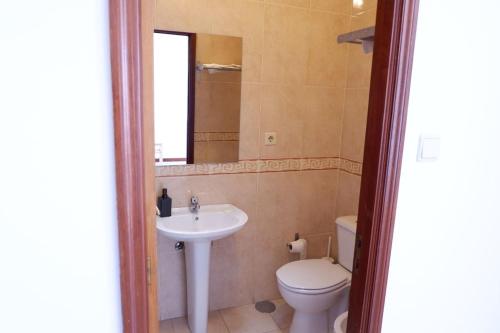 a bathroom with a sink and a toilet and a mirror at Kame House in Vila Nova de Gaia