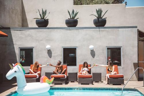 a group of women sitting on chairs by a pool at Hotel Angeleno in Los Angeles