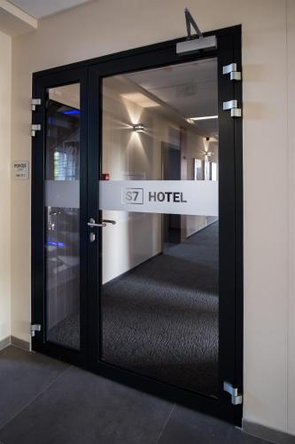 a glass door with a sign that reads hotel at S7 Hotel in Kielce