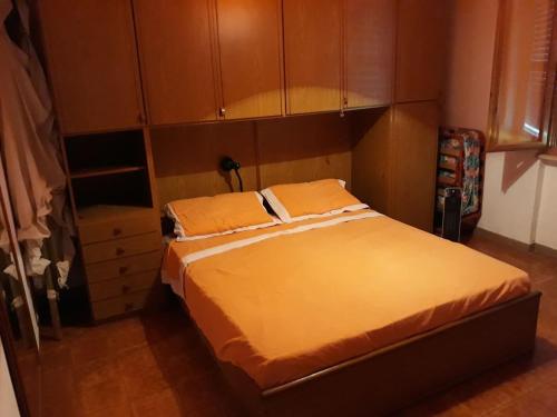 a bedroom with a large bed with wooden cabinets at NOVITA'!! Intero appartamento a Marina di Cecina in Marina di Cecina