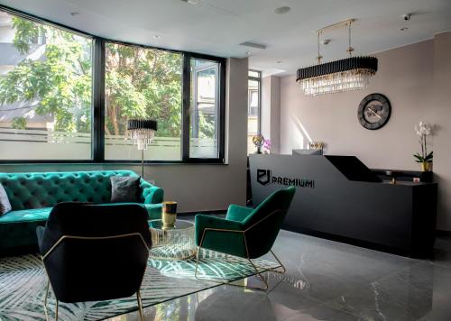 a living room with a couch and chairs and a piano at Hotel Premium in Skopje