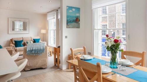 a living room with a table with a vase of flowers at The King's- Gorgeous City Centre Apartment in York