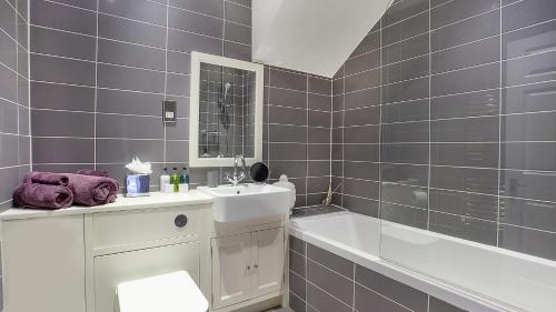 a bathroom with a sink and a bath tub and a sink at The King's- Gorgeous City Centre Apartment in York
