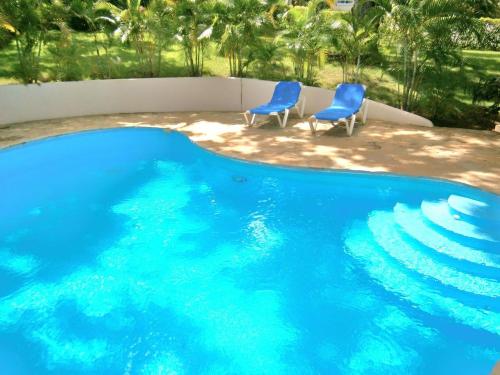 2 sillas azules sentadas junto a una piscina en VillaTracey! Modern 4BR 3BA Sosua Ocean View Villa with Private Pool in Gated Community #15, en Sosúa