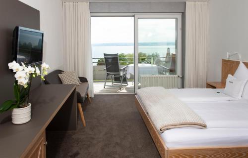 ein Hotelzimmer mit einem Bett und einem Balkon in der Unterkunft Hotel Freisicht in Hagnau