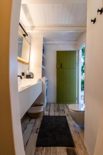 a bathroom with a green door and a tub at villa lord in Pollonia
