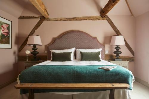 a bedroom with a large green bed with two lamps at Crown and Anchor in Marlborough