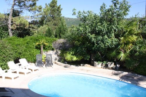 - une piscine avec des chaises longues dans l'établissement Grand gîte Ardèche L'Avventura, à Grospierres