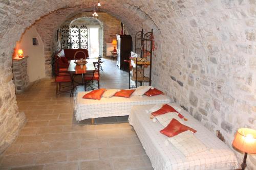 een kamer met 2 bedden in een stenen muur bij Grand gîte Ardèche L'Avventura in Grospierres