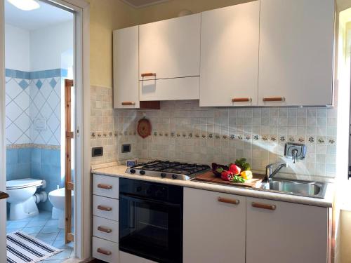 a kitchen with white cabinets and a stove top oven at House Blue Sky by Holiday World in Genoa