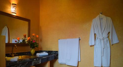 La salle de bains est pourvue d'un peignoir accroché au mur. dans l'établissement Tizi N'Ouirgane, à Marrakech