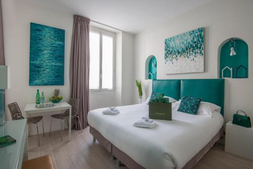 - une chambre avec un grand lit et une table dans l'établissement O Carré Croisette Cannes, à Cannes