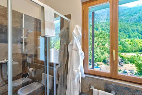 Cimego的住宿－Hotel Aurora，带淋浴和盥洗盆的浴室以及窗户。