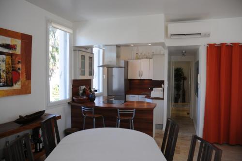 une cuisine avec une table et des chaises dans une pièce dans l'établissement Appartement cosy 100 m2 - climatisé - calme -centre-ville, à Hyères
