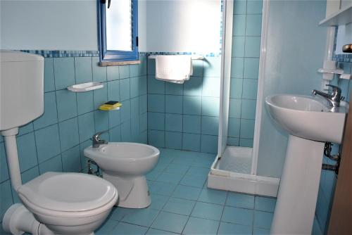 a blue bathroom with a toilet and a sink at Casevacanze Le Muse in Menfi