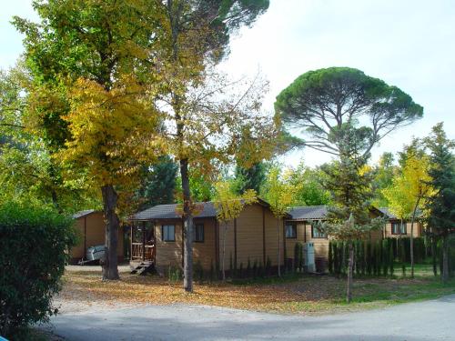 a small house with trees in front of it at Aranjuez Camping & Bungalows in Aranjuez