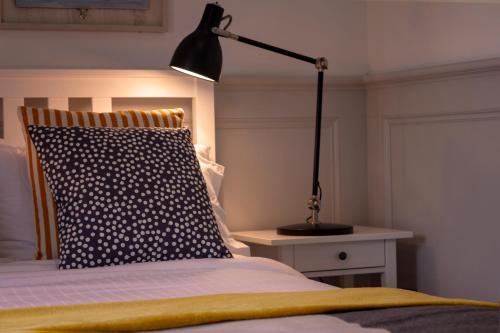 a bedroom with a bed with a pillow and a lamp at The Nest in Youghal