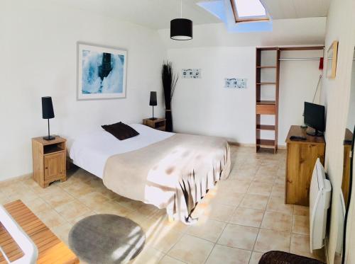 - une chambre avec un lit et une télévision dans l'établissement APPART HÔTEL MON CALME, à Piriac-sur-Mer
