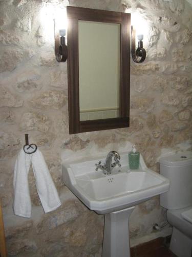 a bathroom with a sink and a mirror and a toilet at Casa Rural Los Yeros Aldeasoña - Segovia in Aldeasoña