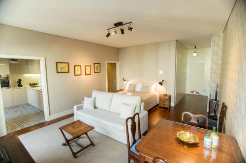 a living room with a white couch and a bed at Cardosas Square Luxury Apartments by Porto City Hosts in Porto