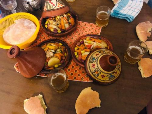 una mesa de madera con platos de comida y copas de cerveza en MAISON DU KERMA en Fez