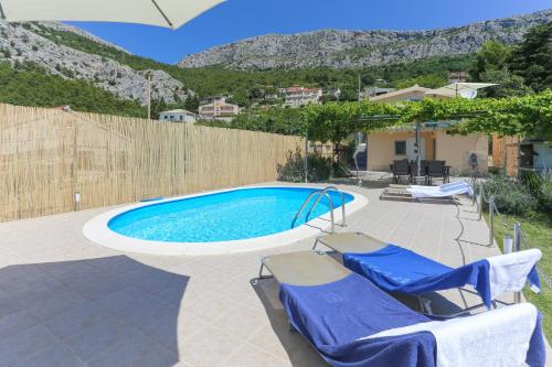 a swimming pool with two lounge chairs next to it at Holiday Home Rupotina with a large yard, pool and a beautiful view in Solin