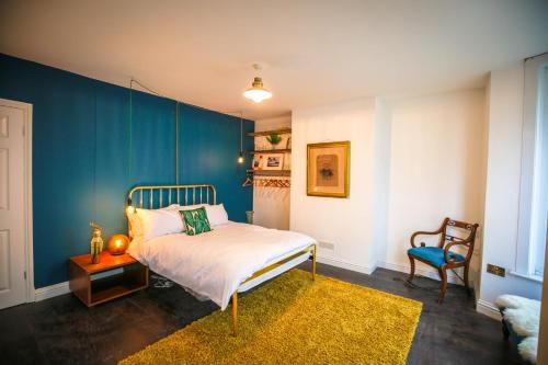 a bedroom with a bed and a blue wall at Eclectic seaside 4 bedroom artists residence in Margate
