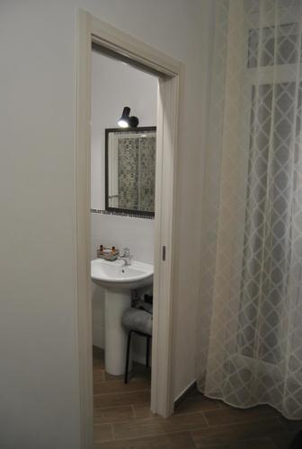 une salle de bain avec un lavabo et un miroir dans l'établissement La Triade affittacamere, à Syracuse