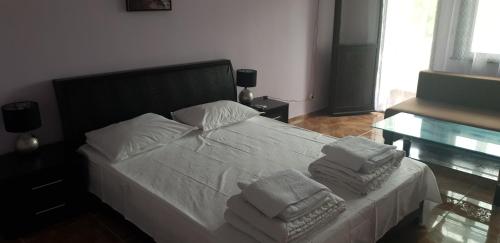a bedroom with a white bed with towels on it at Свети Никола in Sinemorets