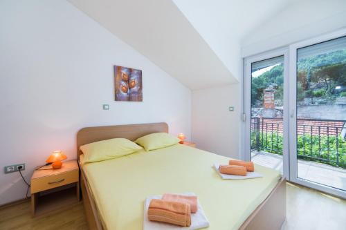 1 dormitorio con cama y ventana grande en Franić Baćina Lakes Apartments, en Ploče