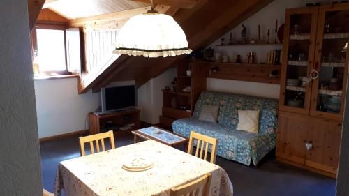 a living room with a table and a couch at Mansarda - La Thuile Frazione Buic in La Thuile