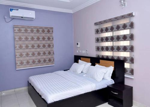 a bedroom with a bed in a room with blue walls at Onimz Apartments in Abuja