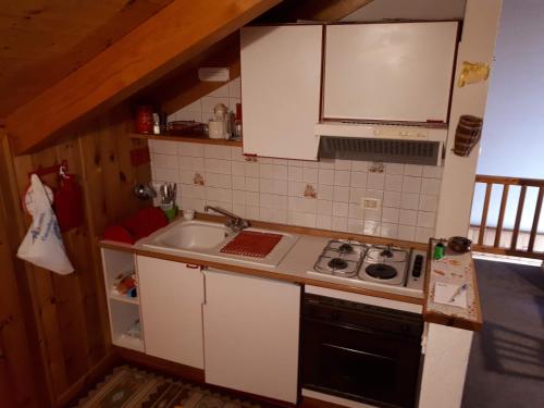 a small kitchen with a sink and a stove at Mansarda - La Thuile Frazione Buic in La Thuile