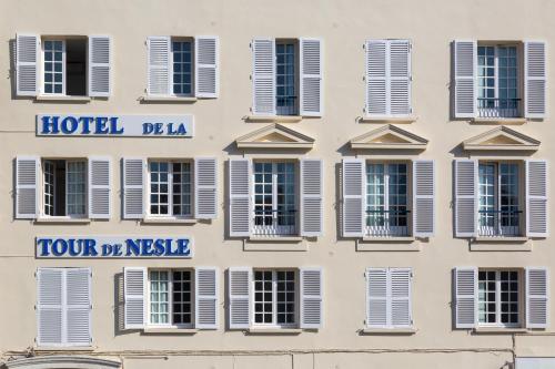 a facade of a hotel with shuttered windows at Hôtel La Tour de Nesle La Rochelle Vieux Port in La Rochelle