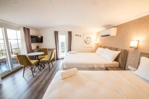 a hotel room with two beds and a table and chairs at dekatria rooms&aparts in Kaş