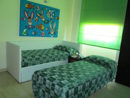 a hotel room with two beds and a painting on the wall at Hotel I Colori in SantʼAntìoco