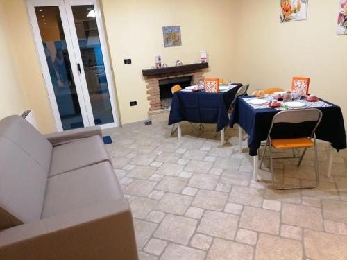a living room with two tables and a fireplace at Nonna Lucia in San Giorgio Ionico