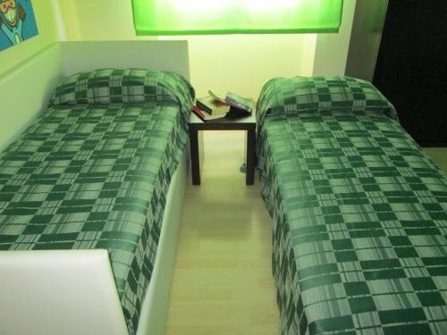 two beds sitting next to a table in a room at Hotel I Colori in SantʼAntìoco