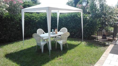 uma mesa branca e cadeiras sob um guarda-chuva branco em 1 La fisarmonica del Conero em Castelfidardo