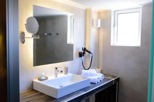 a bathroom with a sink and a mirror at Eva Apartments in Piraeus