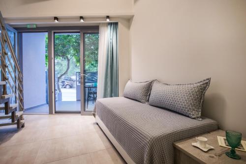 a living room with a bed and a sliding glass door at Mr & Mrs K Lofts in Potos