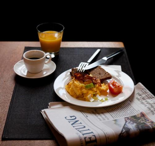a table with a plate of food and a cup of coffee at ONNO Boutique Hotel & Apartments in Rendsburg